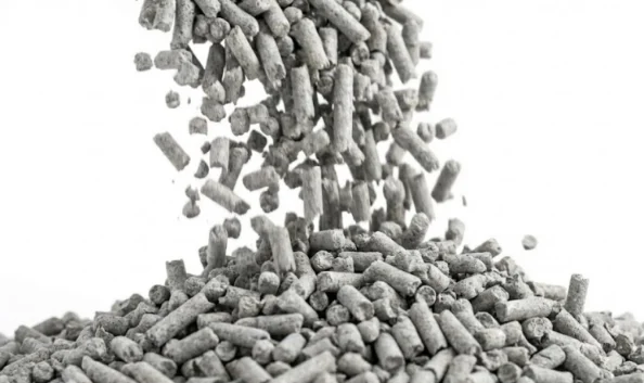 Close-up of dust-free bentonite cat litter pellets pouring cleanly.