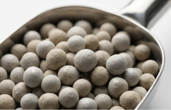 Dust-free bentonite cat litter in a metal scoop.