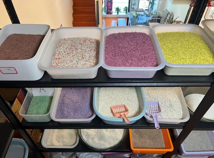 Colorful pellet cat litter displayed in plastic bins on a shelf