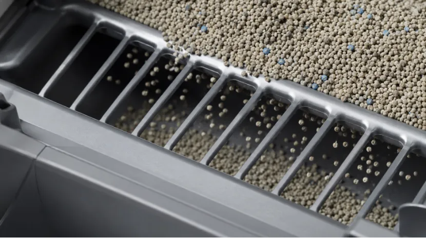 Granules sifting through an automatic litter box screen